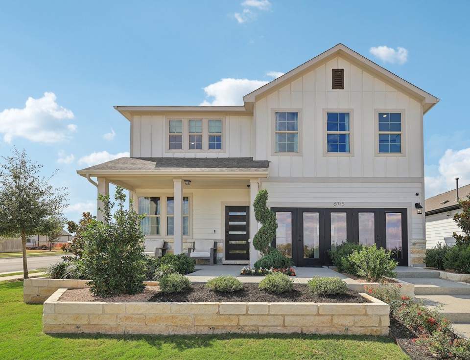 A white house with a green lawn.