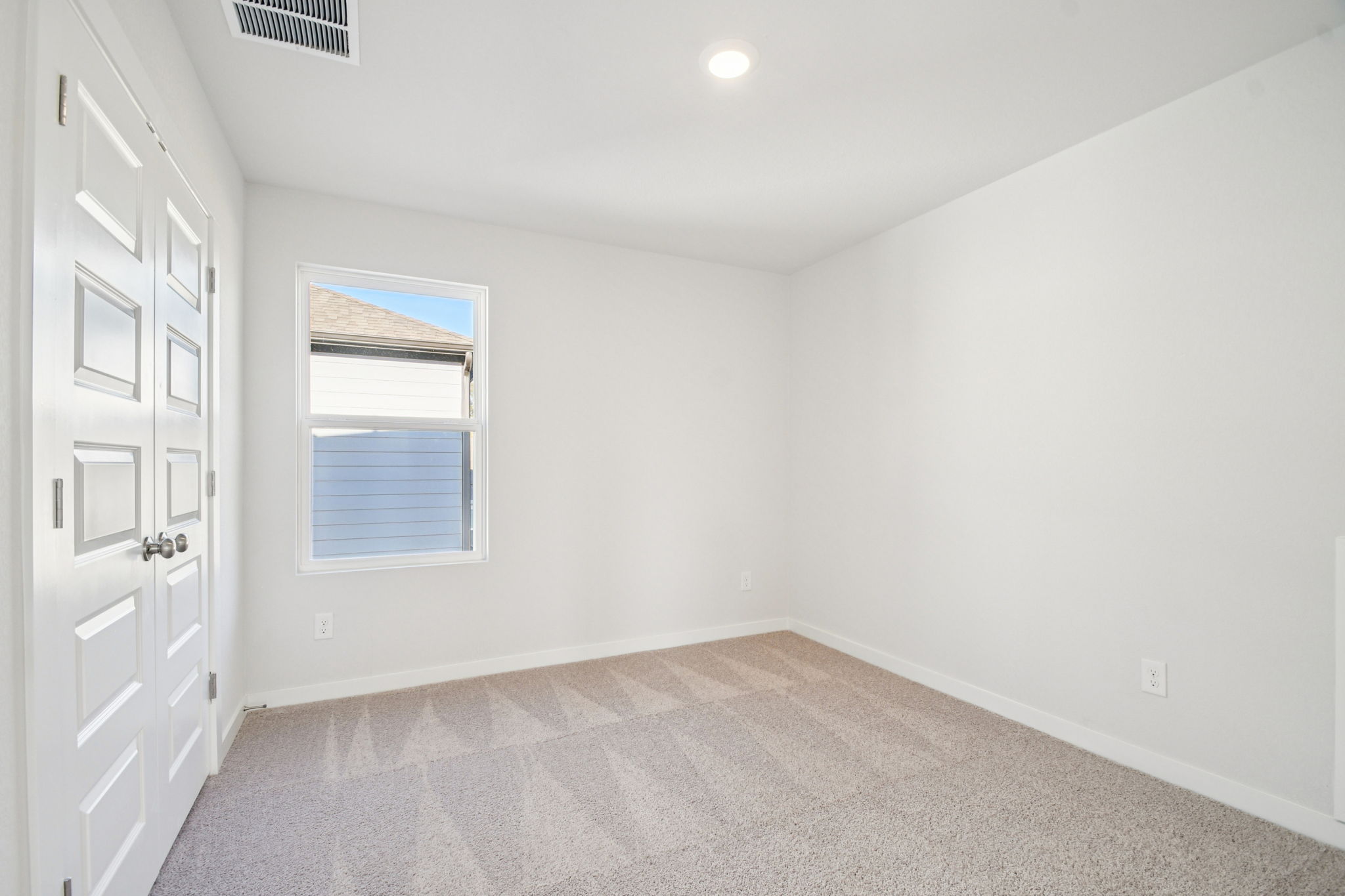 A room with white walls and a window.