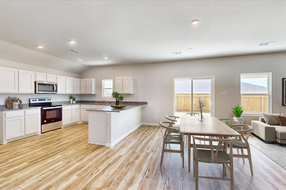 A large kitchen with a dining table.