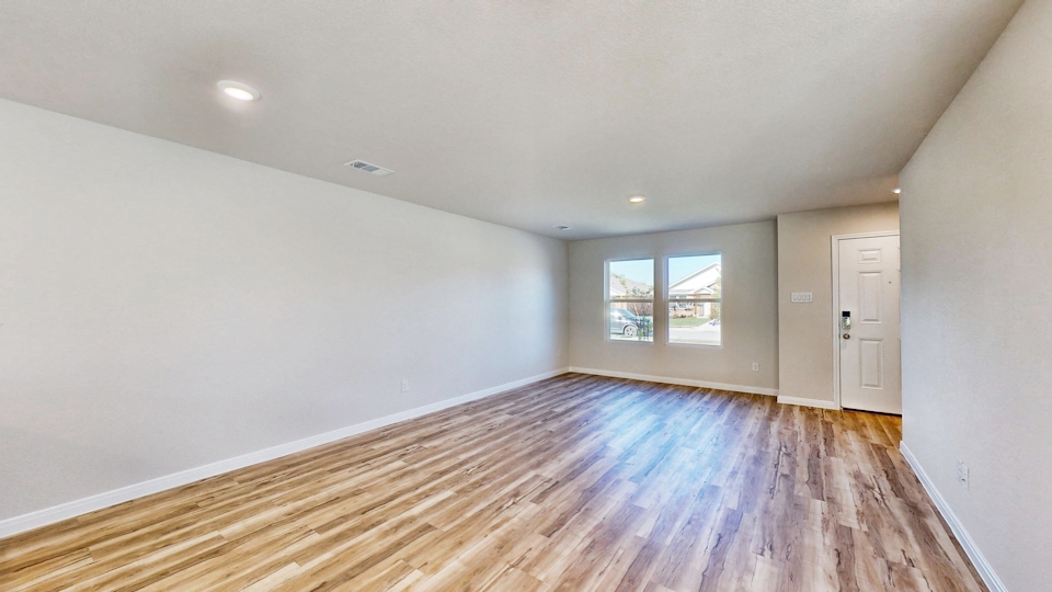A room with a wood floor and a wood floor with a window.