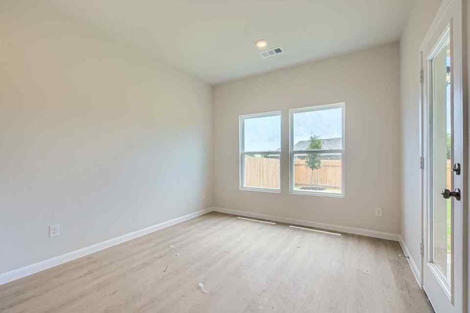 A room with a wood floor and windows.