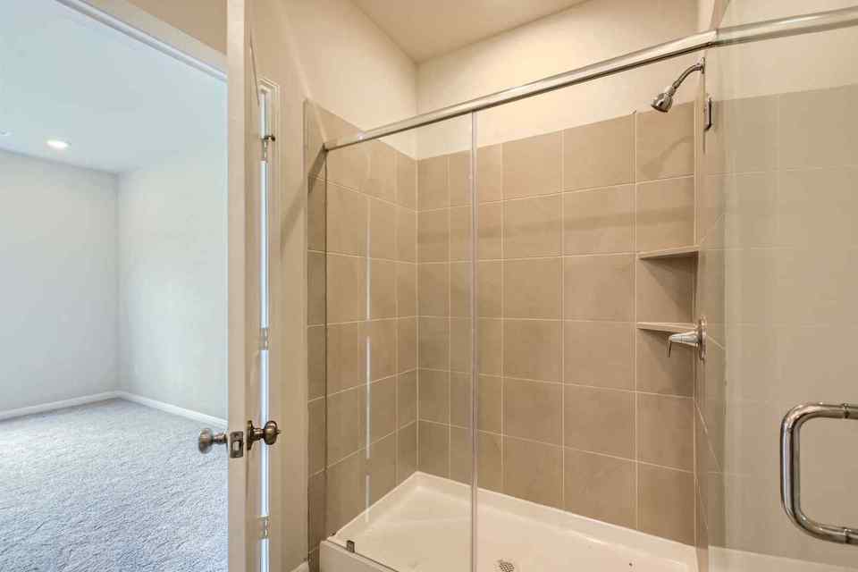 A bathroom with a shower unit and a bathtub.