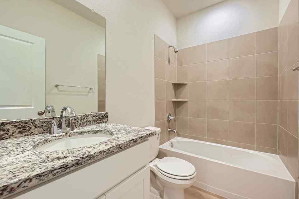 A bathroom with a tub sink and toilet.