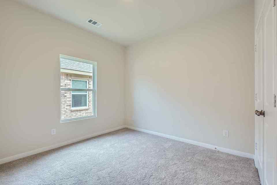 A room with a window and a carpet.