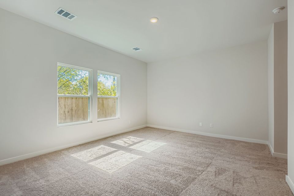 A room with a carpet and windows.