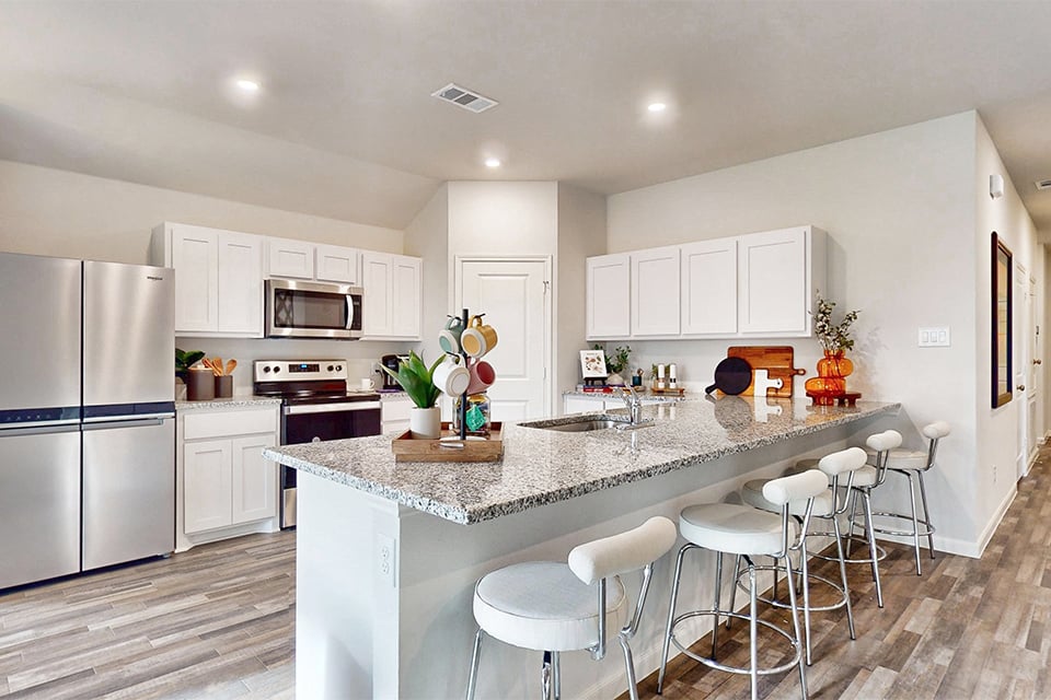 A kitchen with white cabinets.