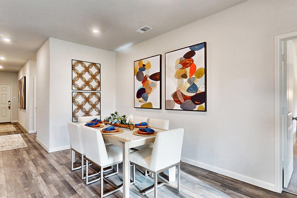 A dining room with a table and chairs.