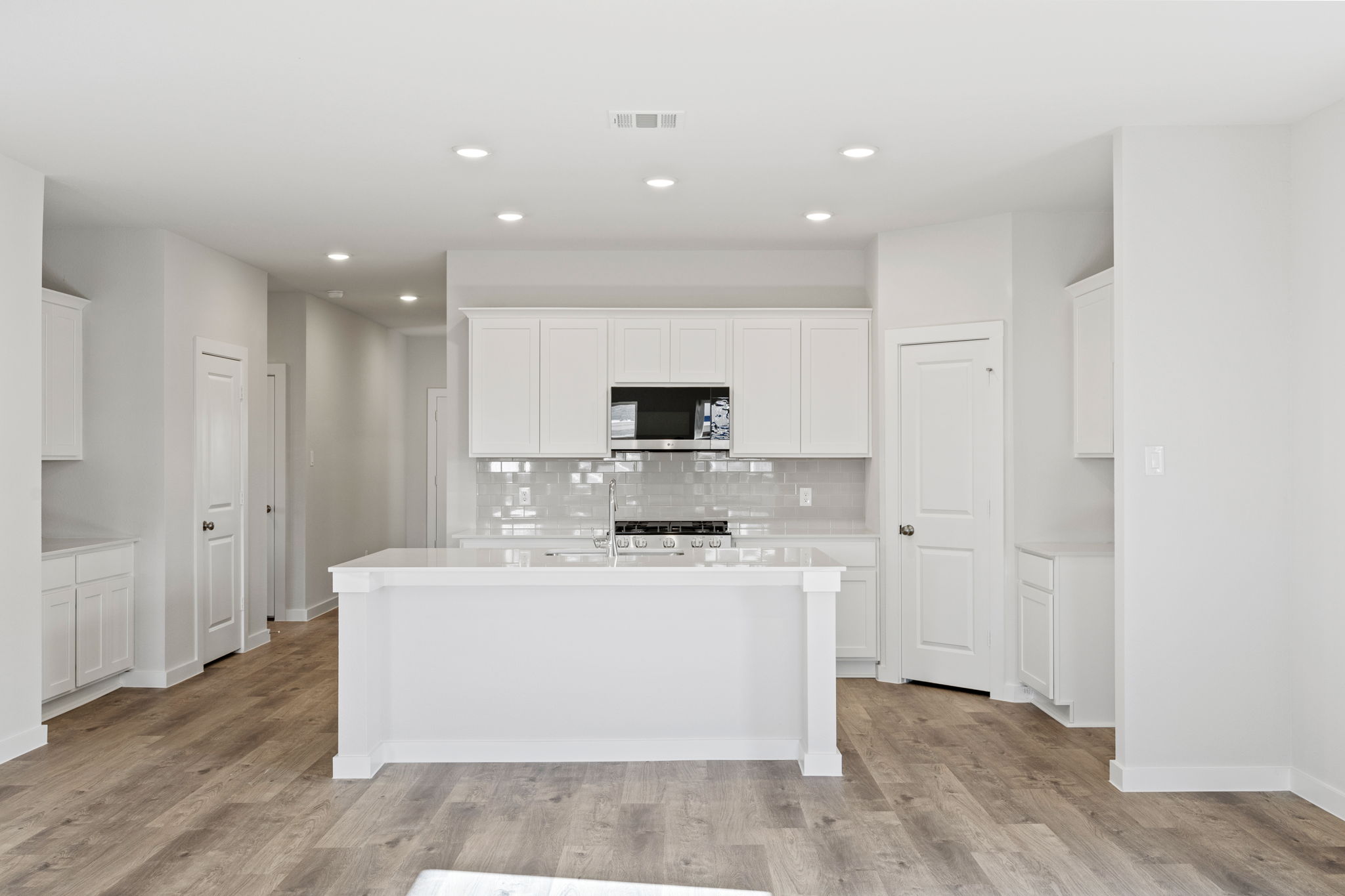 A kitchen with white cabinets.