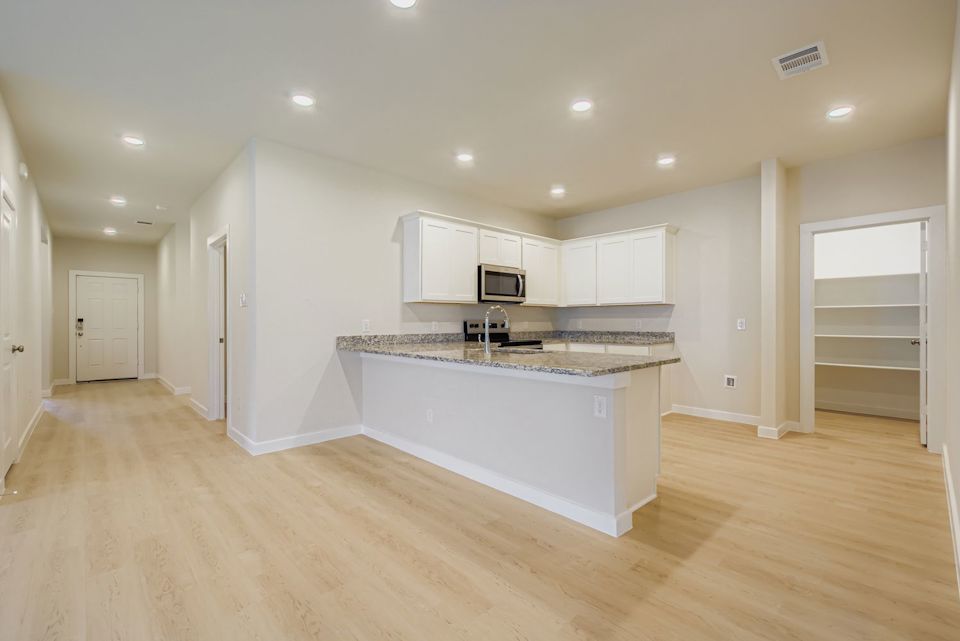A kitchen with white cabinets.