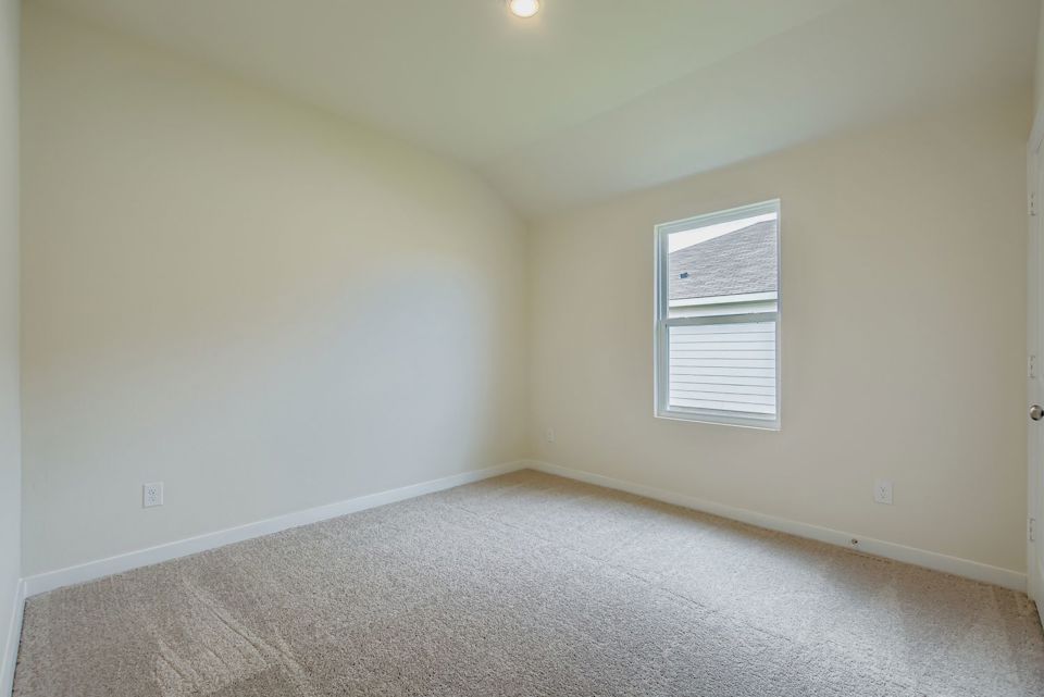 A room with a carpet and a window.