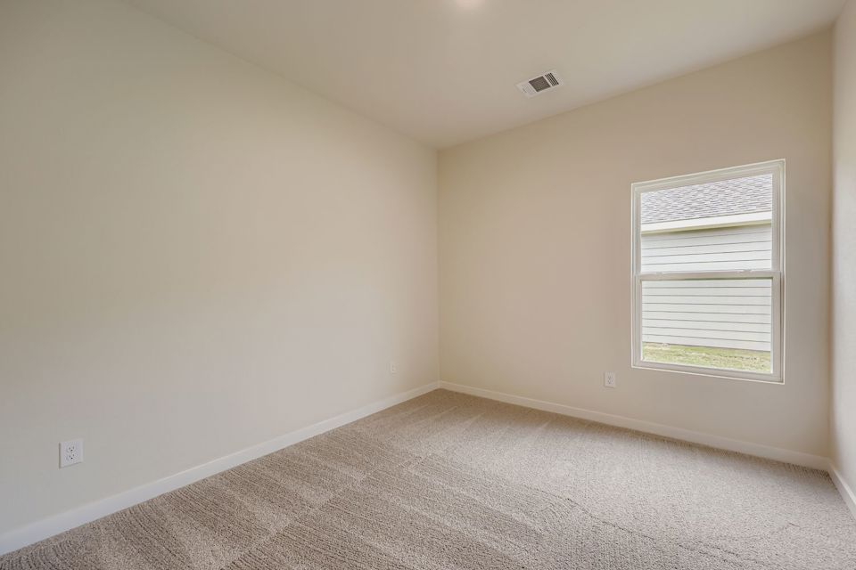 A room with a window and carpet.