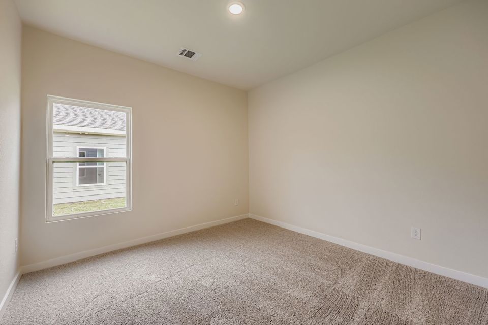 A room with a window and carpet.