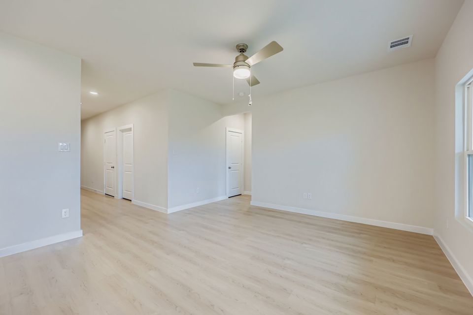 A room with a wood floor and a ceiling fan.