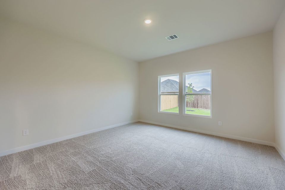 A room with a carpet and a window.