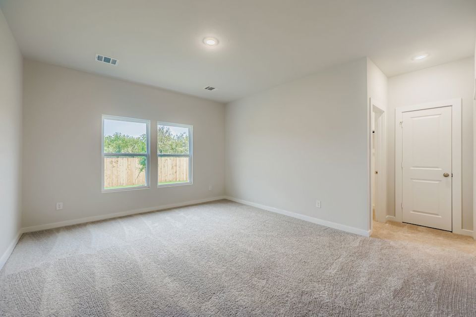A room with a carpet and a window.