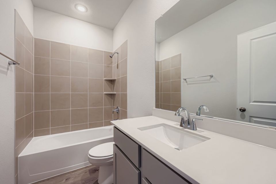 A bathroom with a tub sink and toilet.