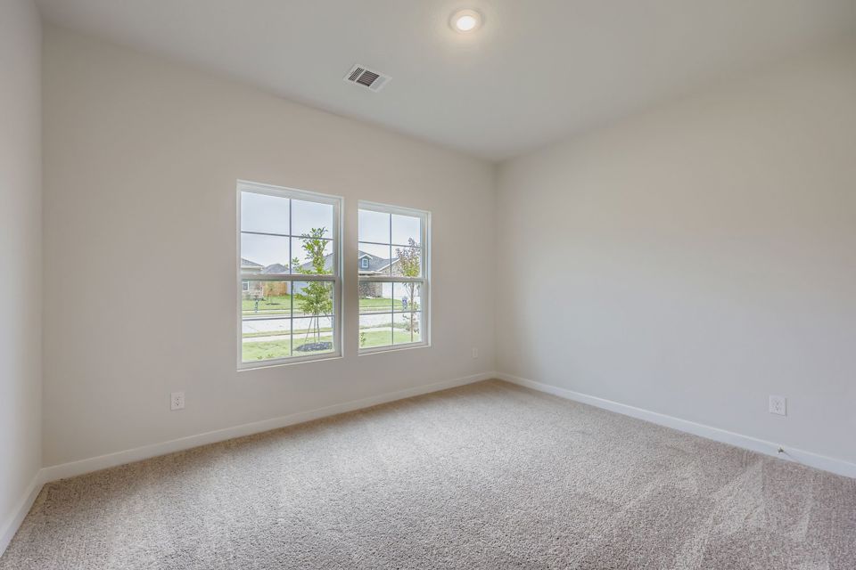 A room with a window and a white wall.