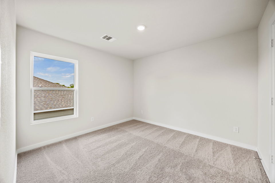 A room with a window and a rug.
