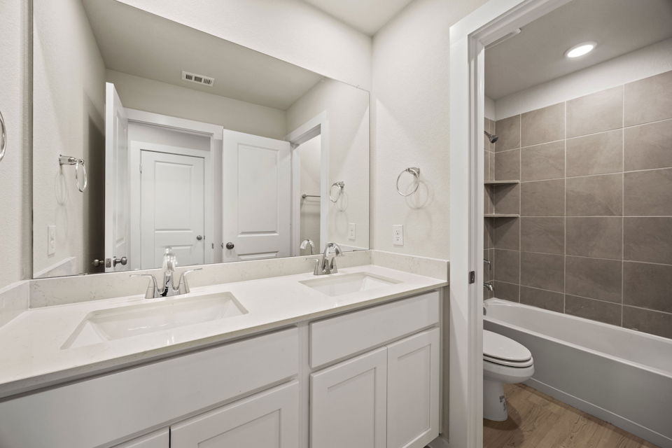 A bathroom with a tub sink and toilet.