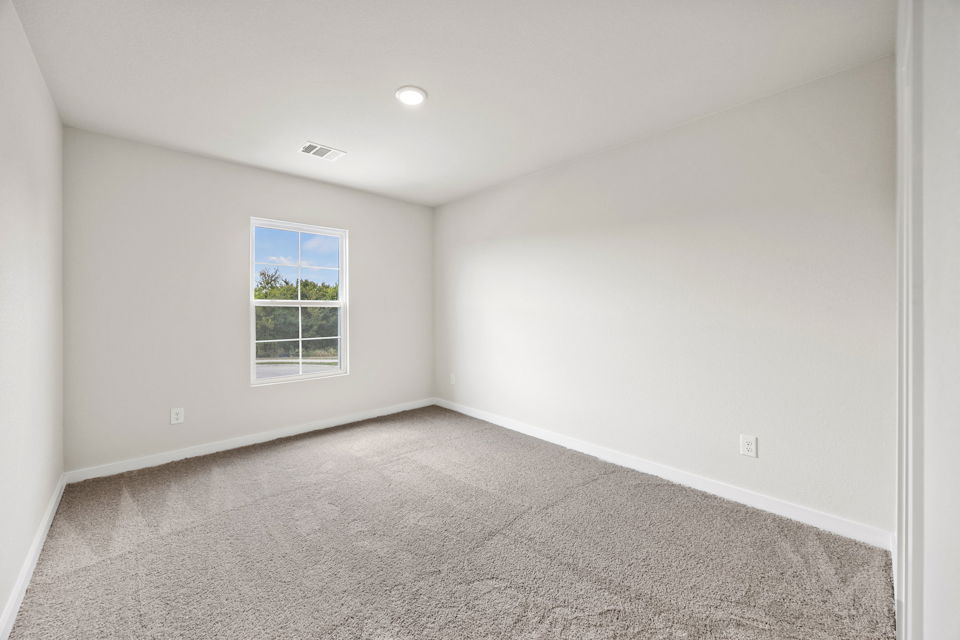A room with a window and a carpet.
