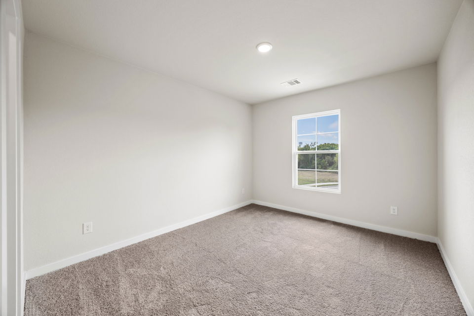 A room with a window and a carpet.