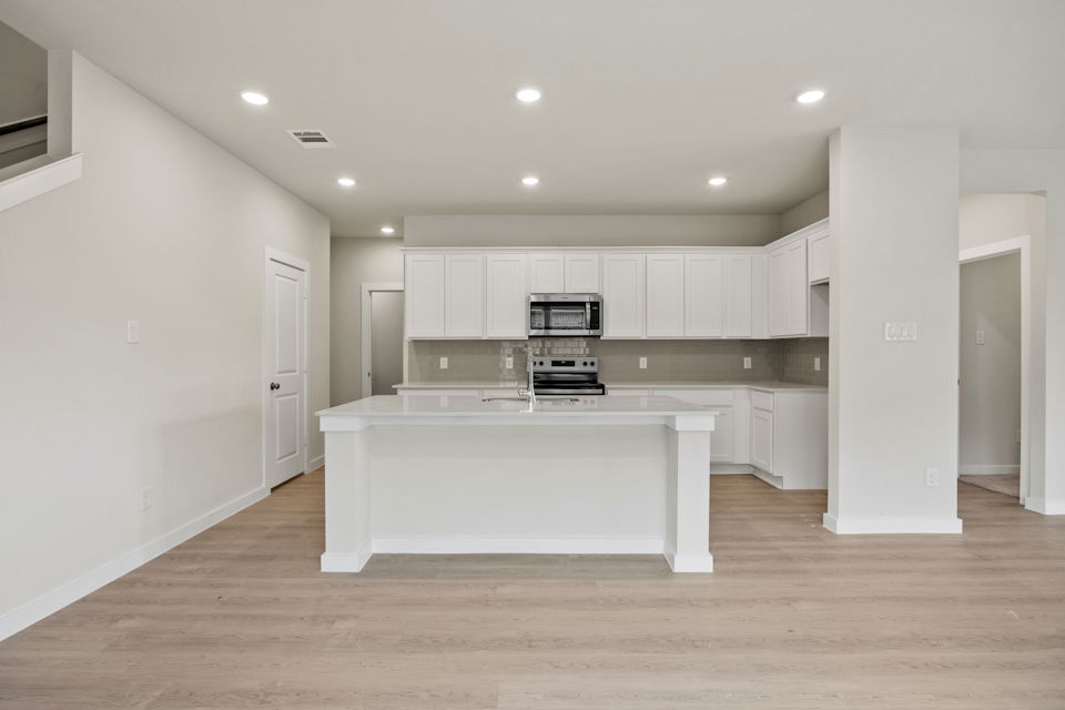 A kitchen with white cabinets.