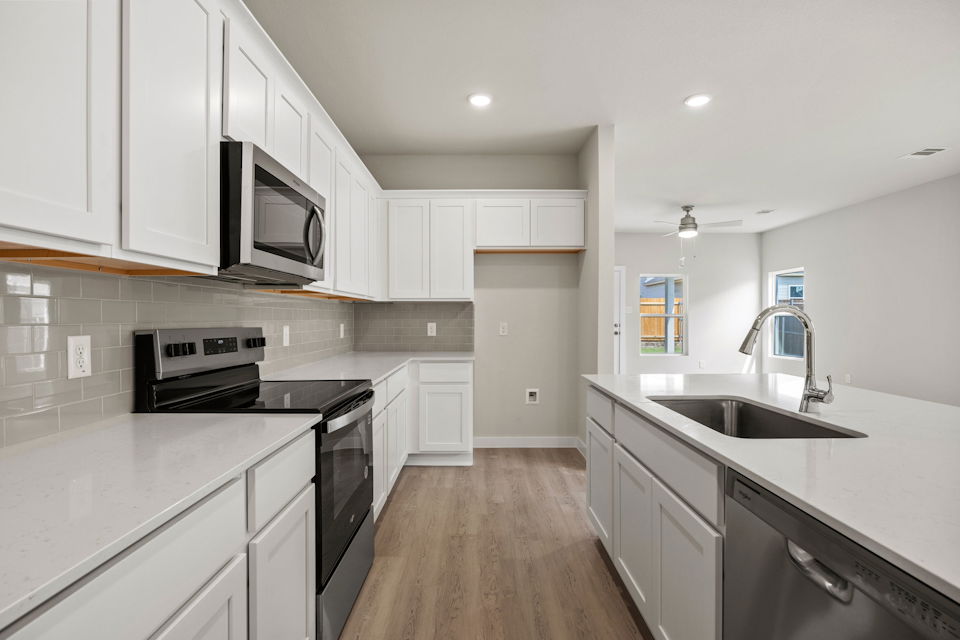 A kitchen with white cabinets.