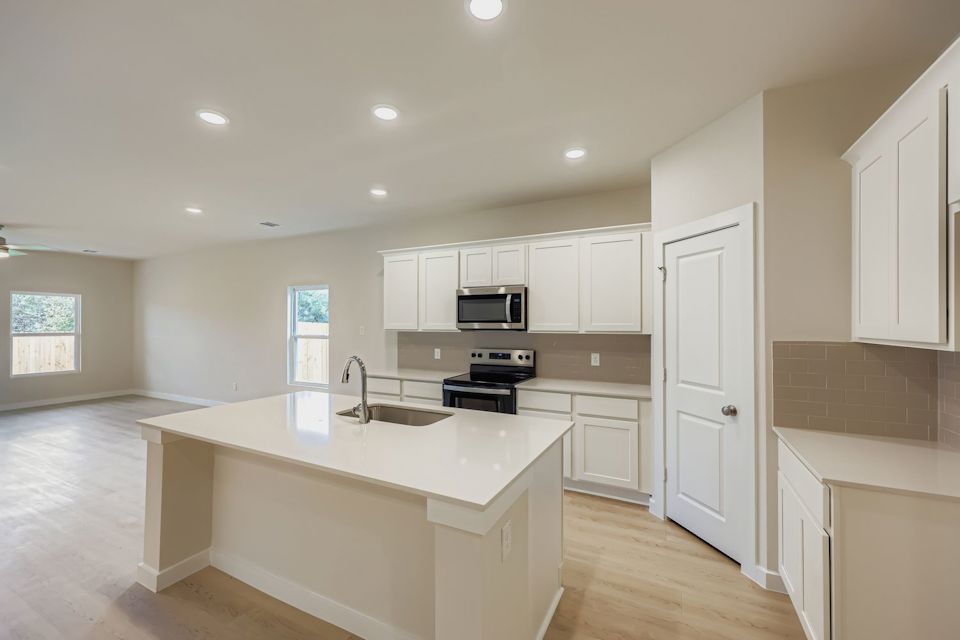 A kitchen with white cabinets.