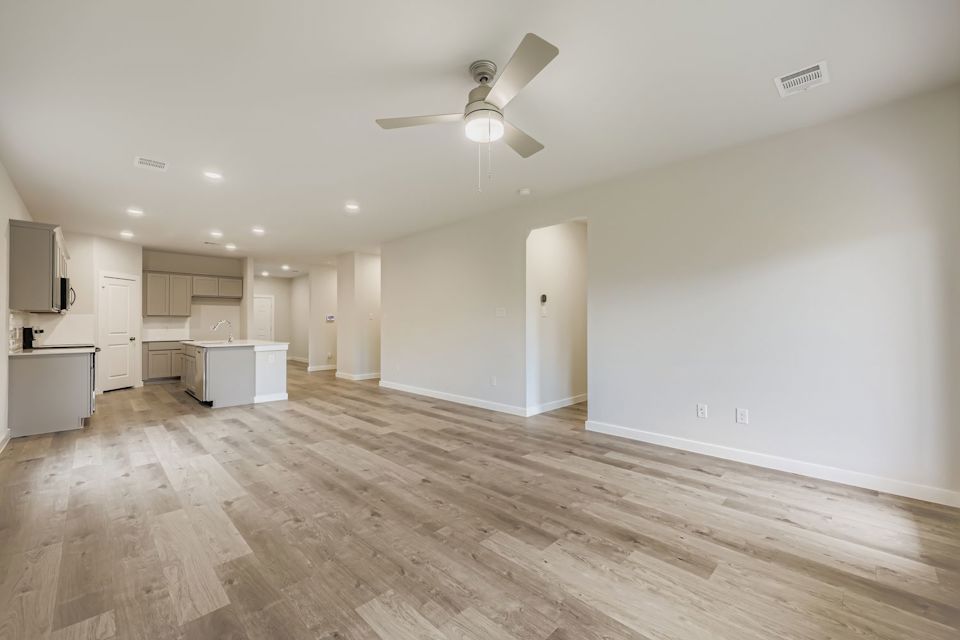 A room with a wood floor and a ceiling fan.