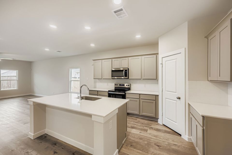 A kitchen with white cabinets.