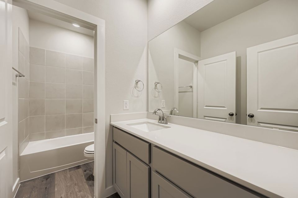 A bathroom with a tub sink and toilet.