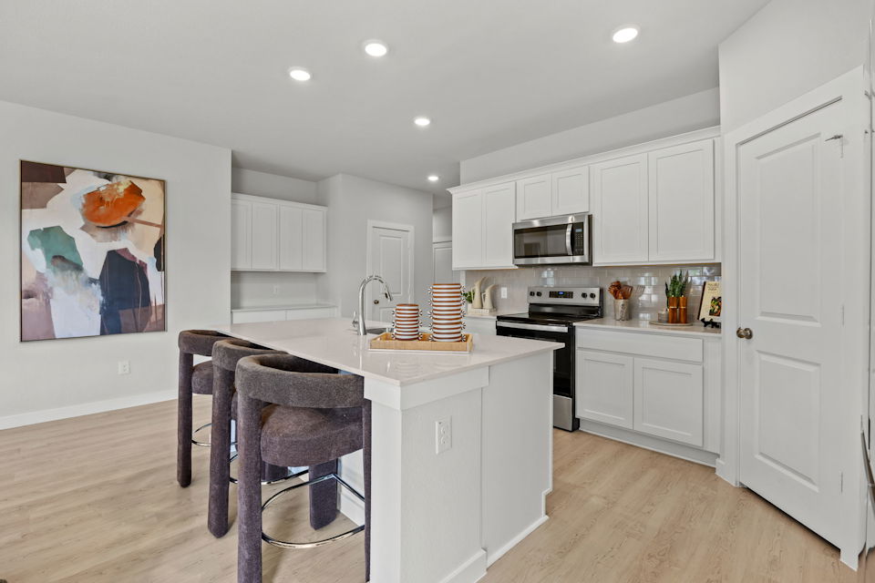 A kitchen with white cabinets.