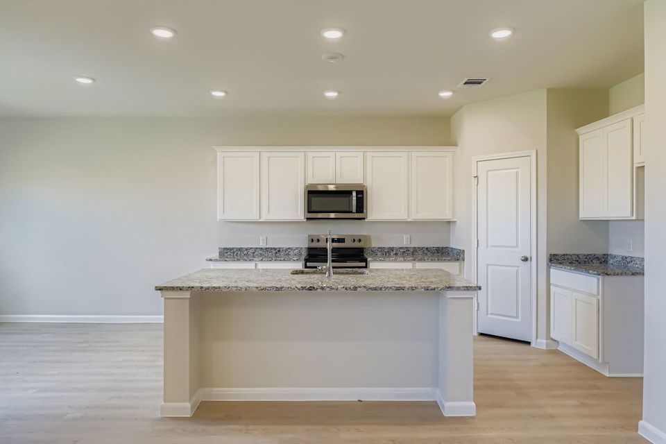 A kitchen with white cabinets.