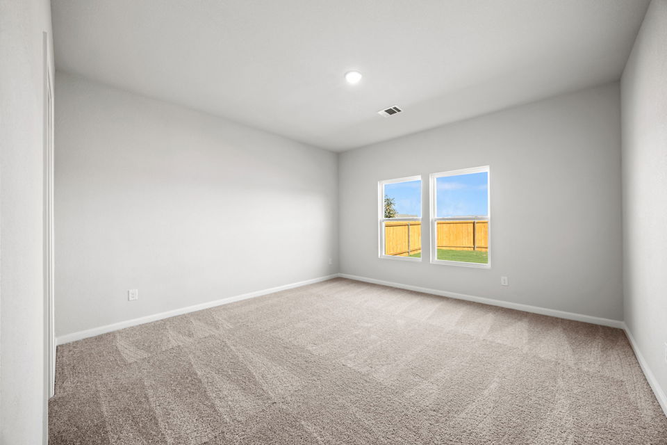 A room with a carpet and windows.