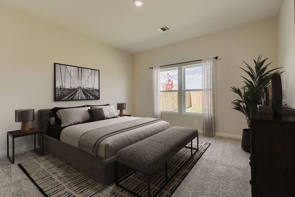 A bedroom with a bed and a chair.