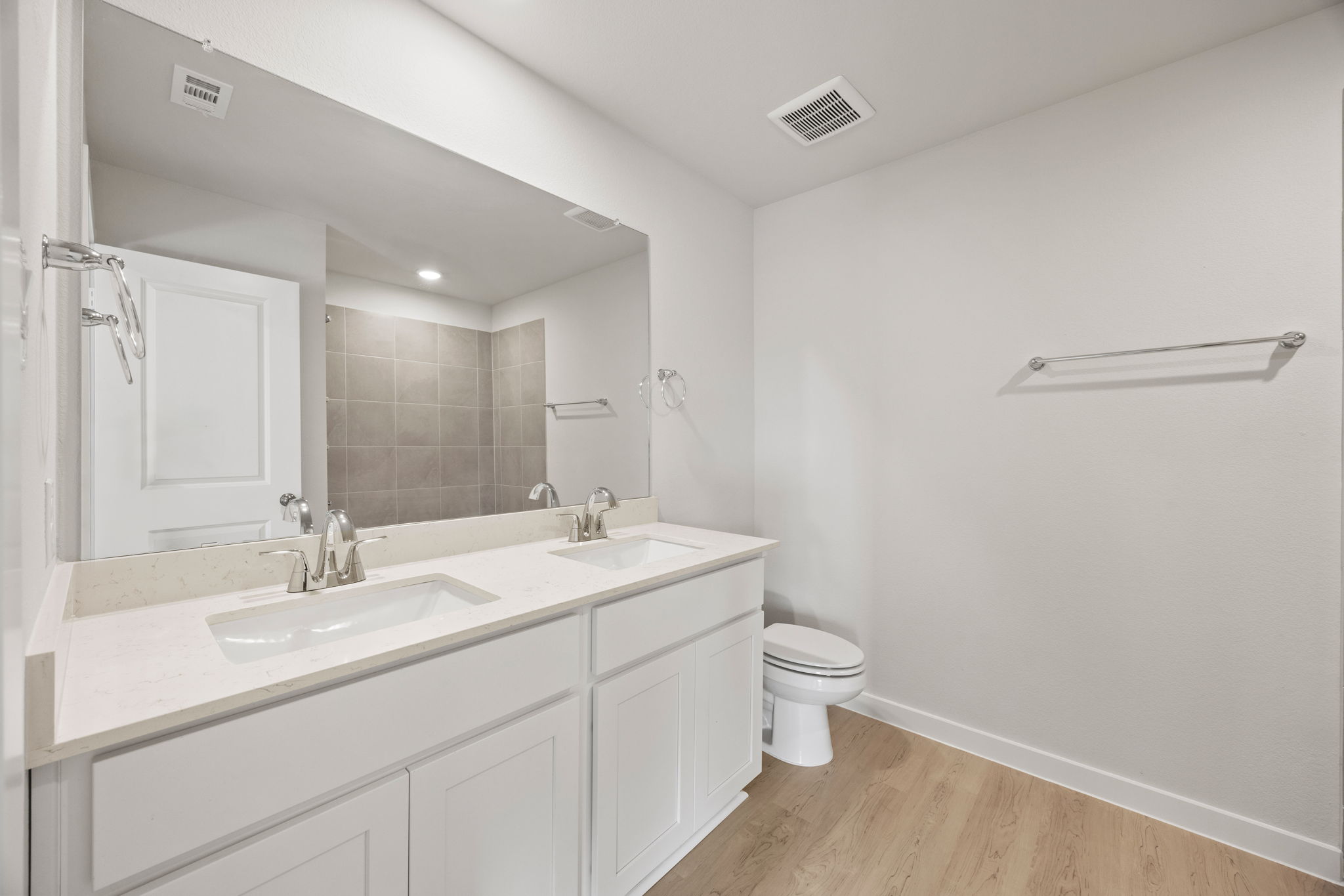 A bathroom with white cabinets.