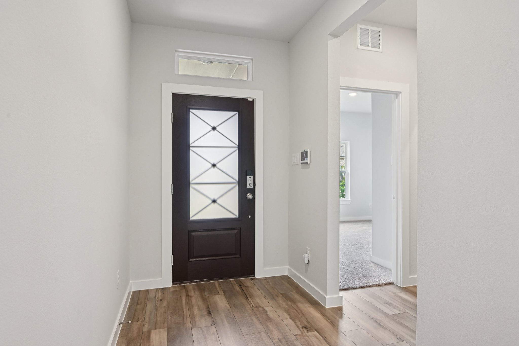 A hallway with a door and a window.
