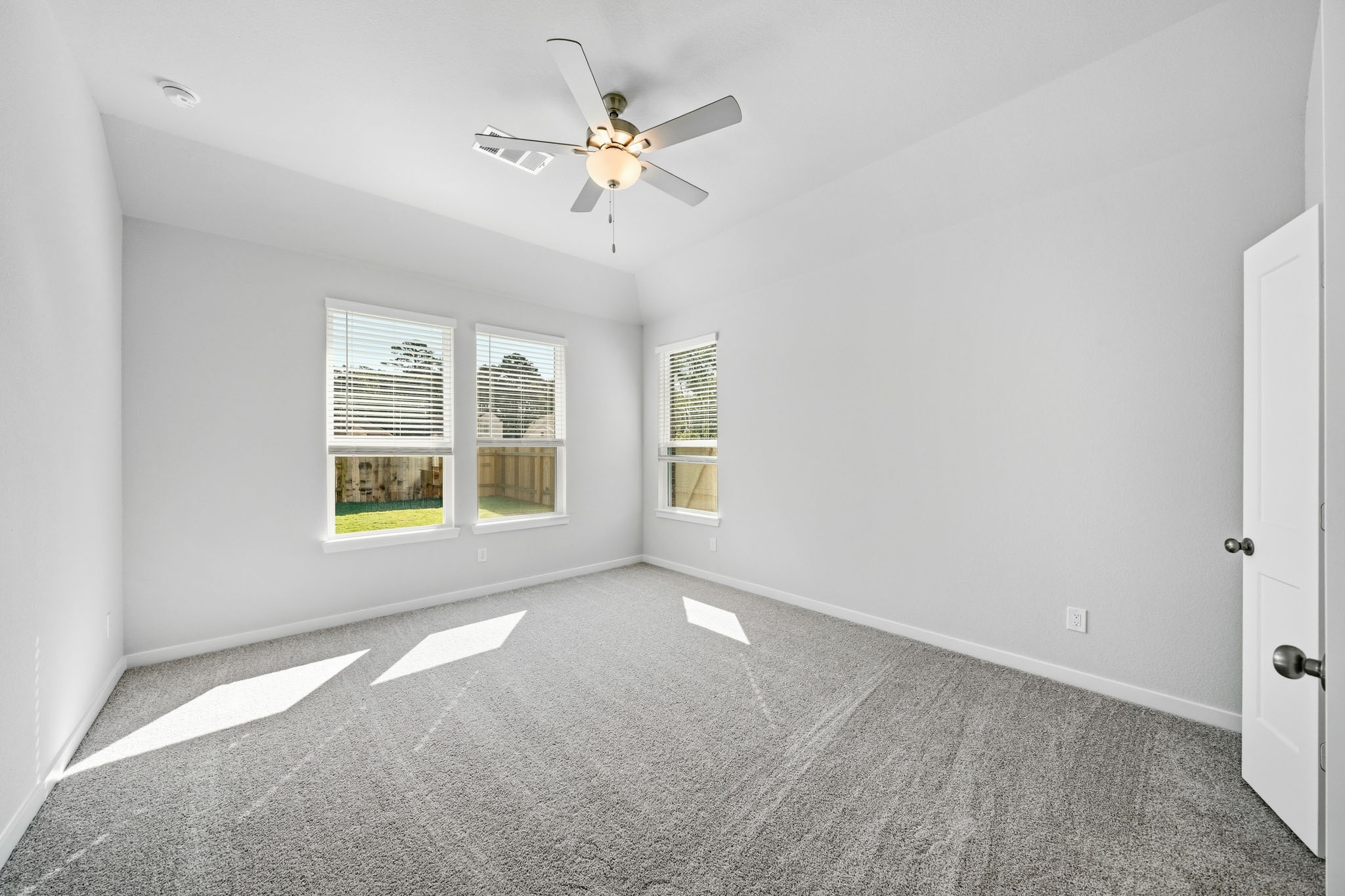 A room with a ceiling fan and a window.