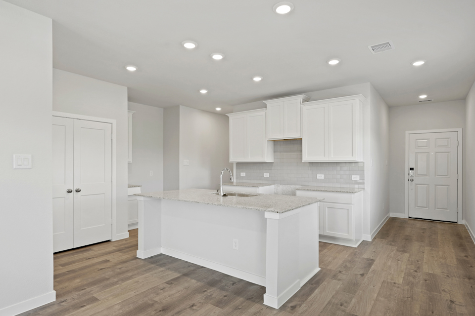 A kitchen with white cabinets.