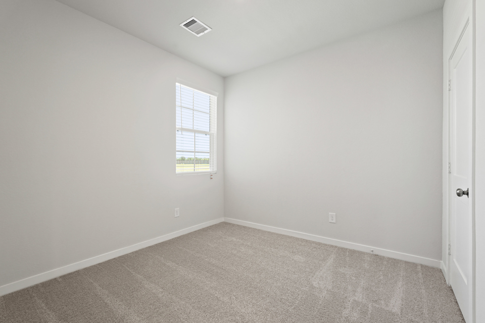 A room with a window and carpet.