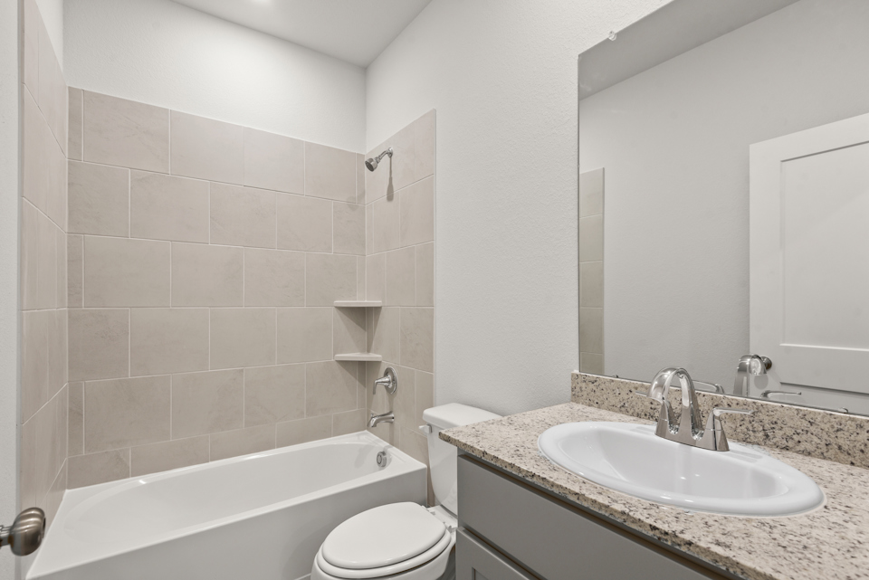 A bathroom with a tub sink and toilet.