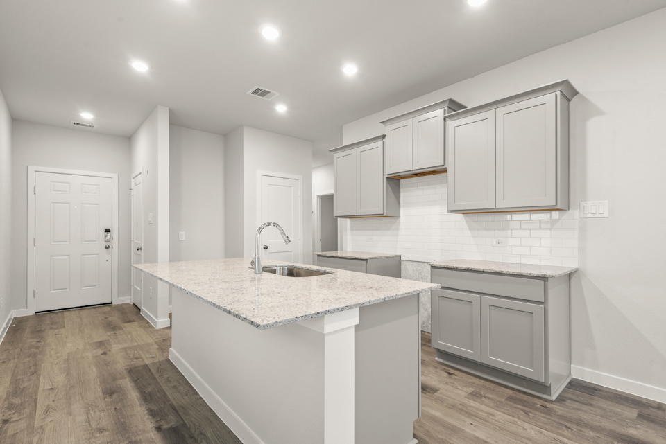 A kitchen with white cabinets.