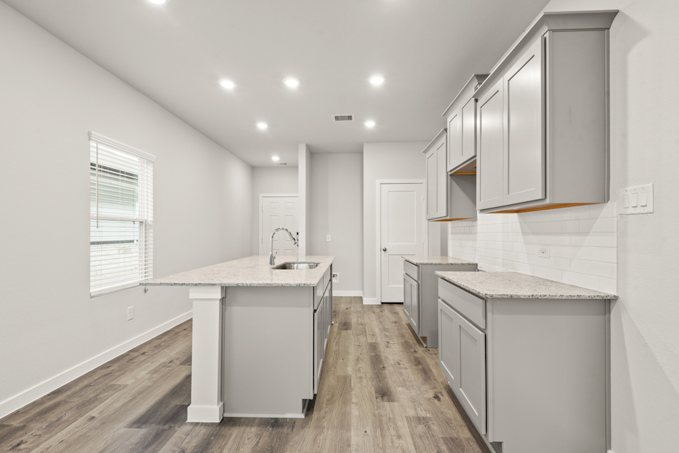 A kitchen with white cabinets.