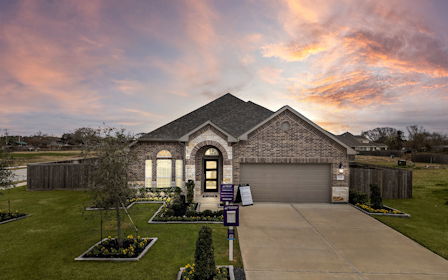A building with a driveway and a sunset in the background.