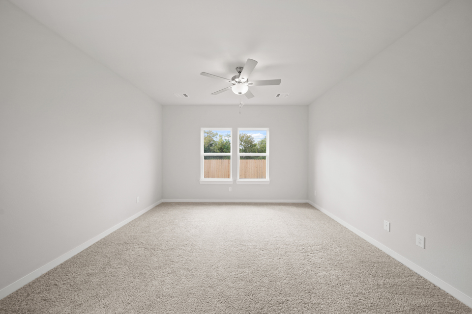 A room with a ceiling fan and a window.
