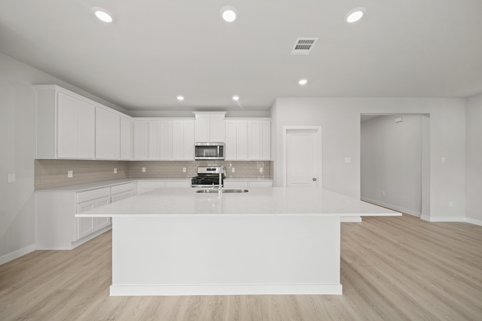 A kitchen with white cabinets.