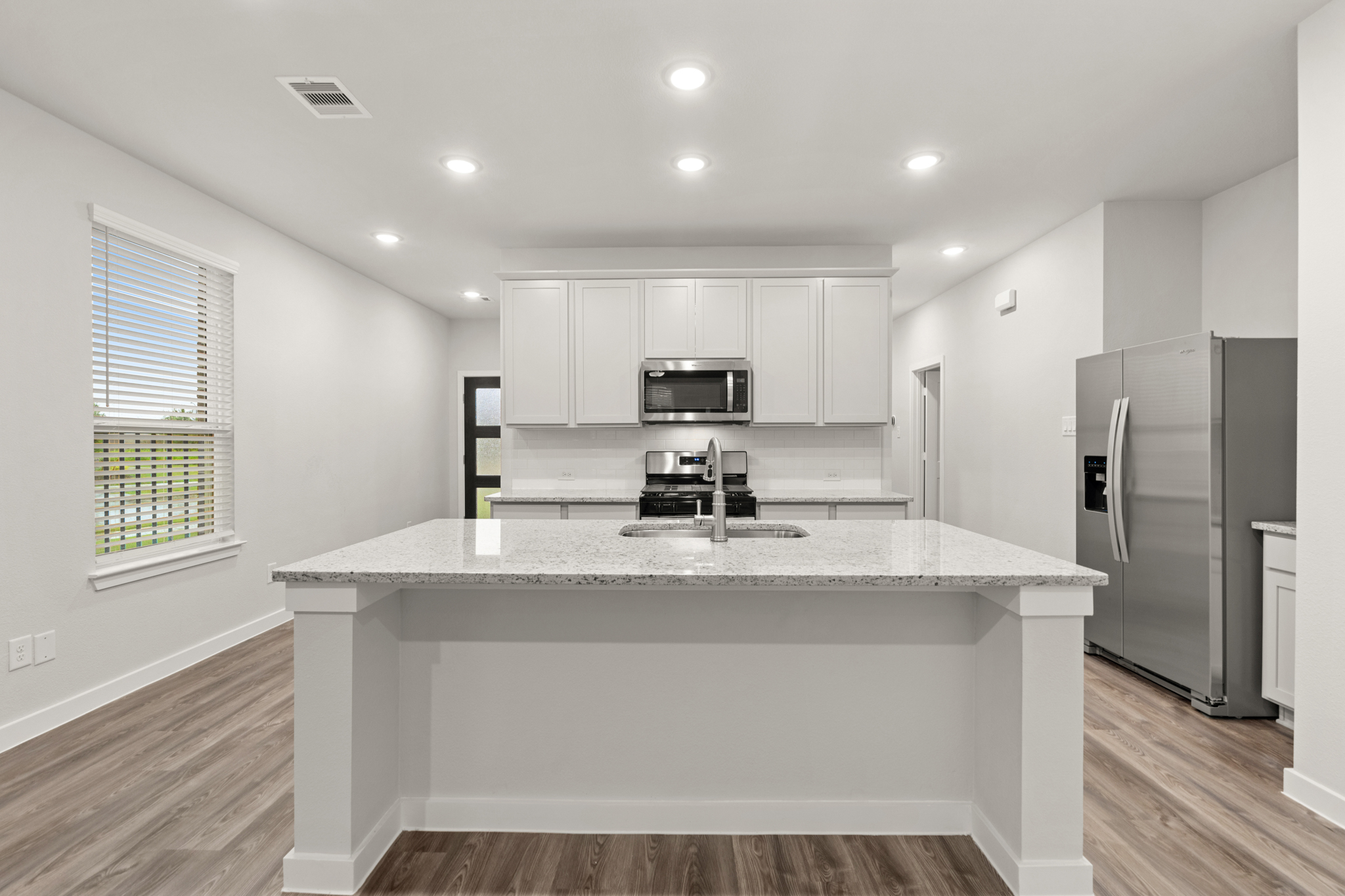 A kitchen with white cabinets.