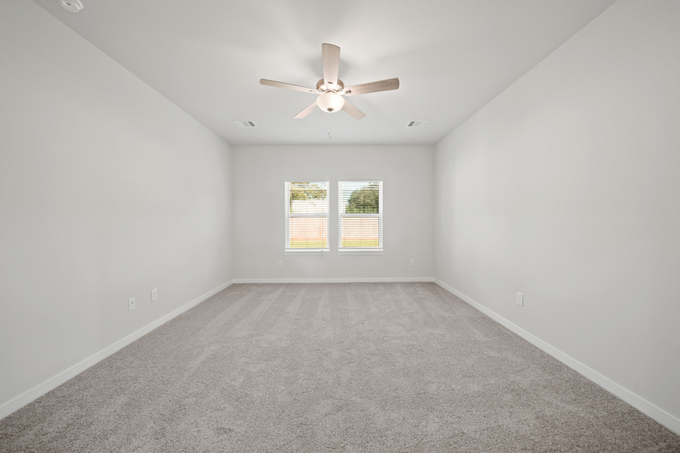 A room with a ceiling fan and a window.
