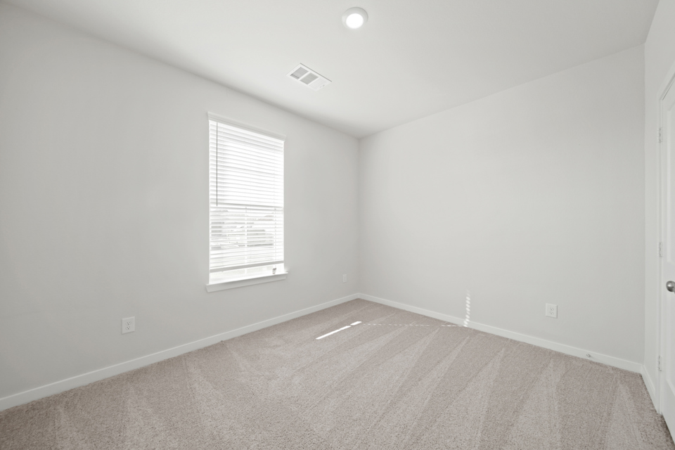 A room with a window and a carpet.