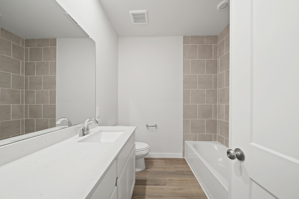 A bathroom with a tub toilet and sink.